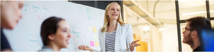 Blonde woman leading a meeting about online reputation management with 3 other people sitting down.