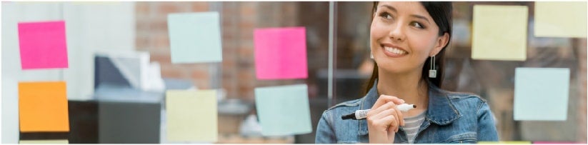 Woman writing post-it notes in office for online reputation management.