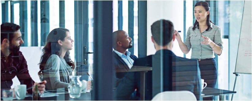 Asian woman leading a meeting about online reputation management with four people in a conference room.