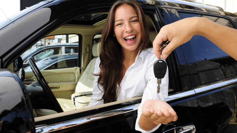Woman sitting in her new car.
