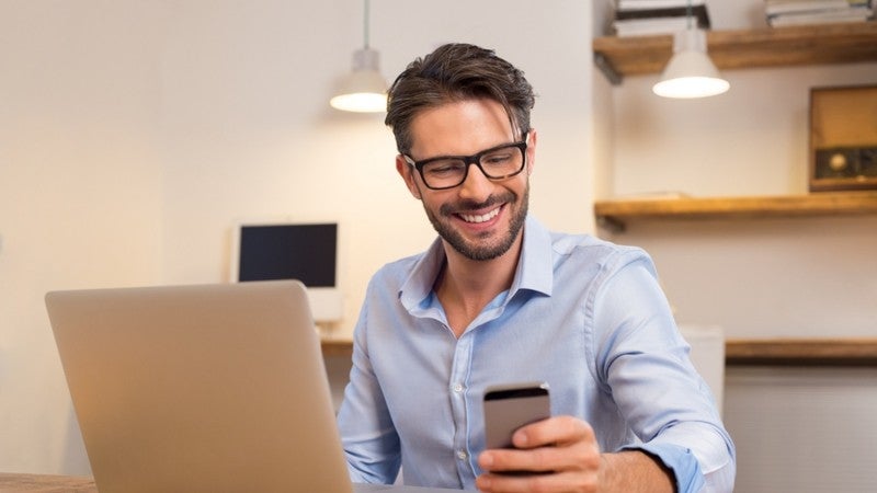Happy customer leaving a review on his phone.