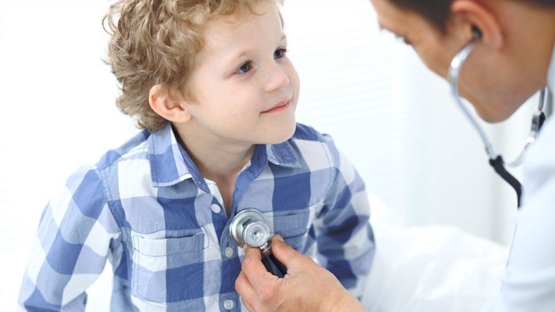 Medical doctor listening to a childs heart with a stethoscope.