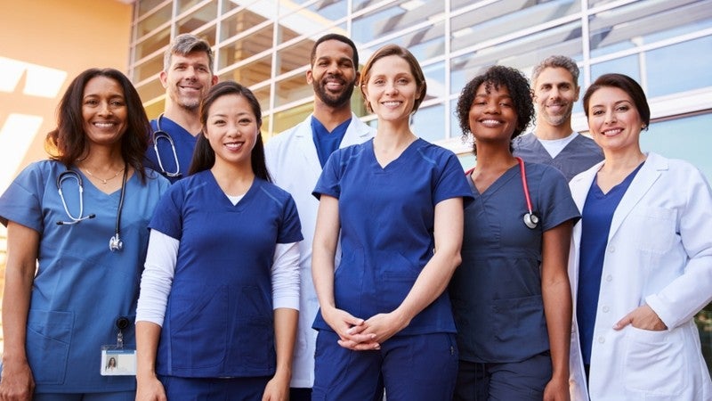 Group of medical personnel standing and smiling.