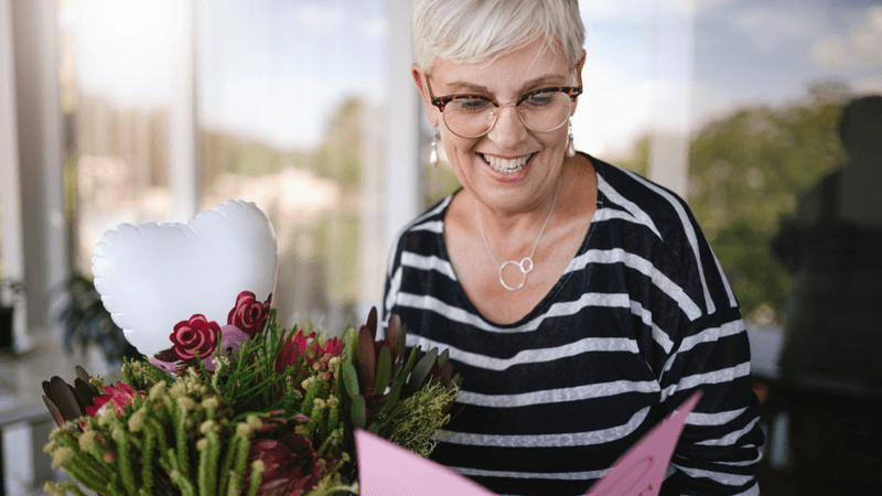 Smiling mom with flowers.