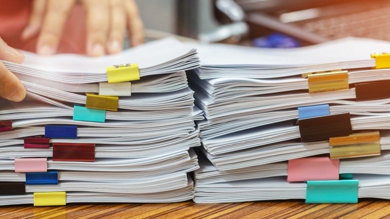 Stacks of documents on a desktop.