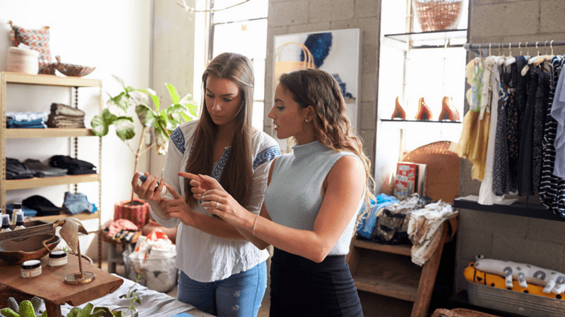 Two women shopping in a clothing store.