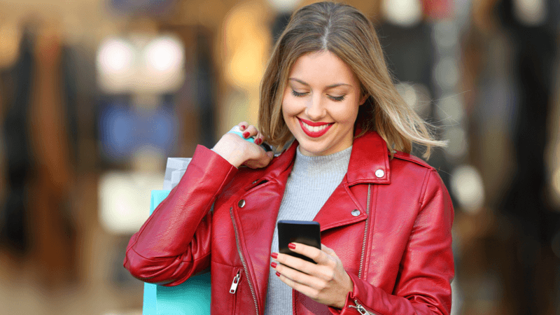 Woman smiling while shopping and completing customer survey.