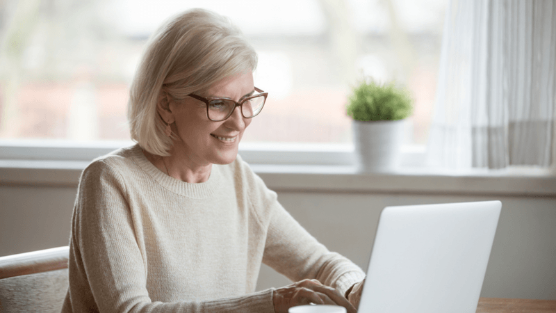 Happy woman typing on a laptop.