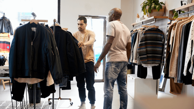 Two men shopping in a clothing store.