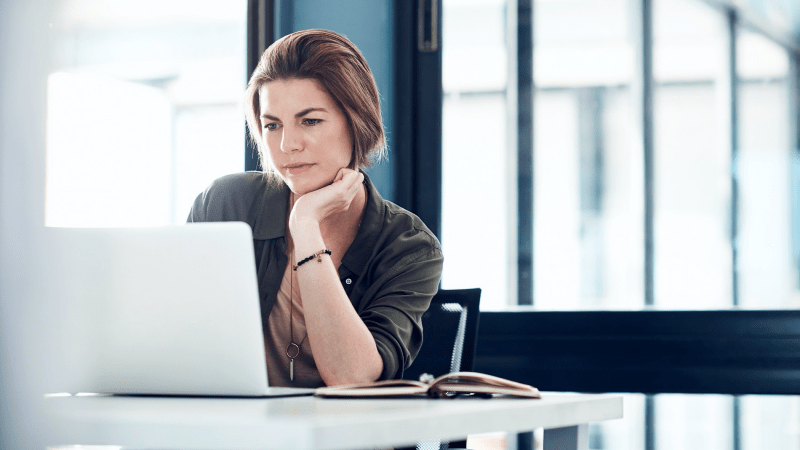 Woman looking intently at her laptop screen.