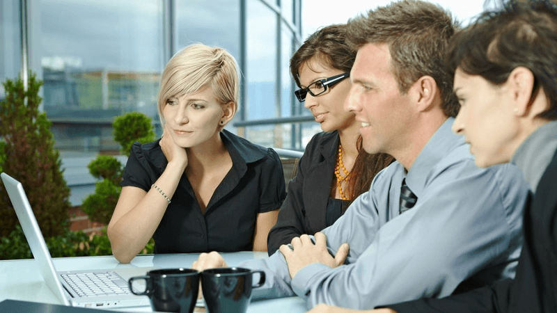 Group of colleagues looking at a computer screen together.