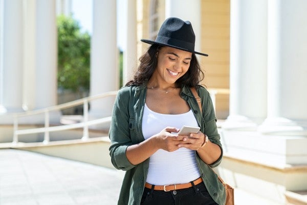 Woman outside typing on her phone. Woman outside typing on her phone.