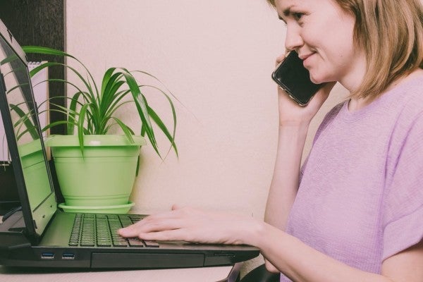 Customer talking on the phone while typing on a computer keyboard. Customer talking on the phone while typing on a computer keyboard.